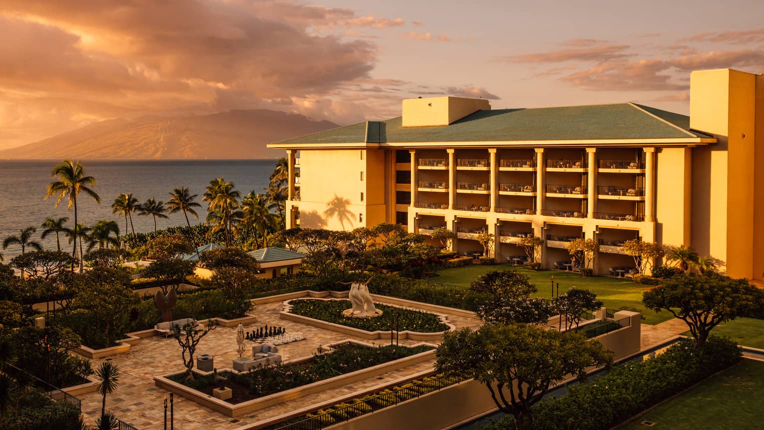 A courtyard, garden and resort exterior at Four Seasons Maui at Wailea at sunset