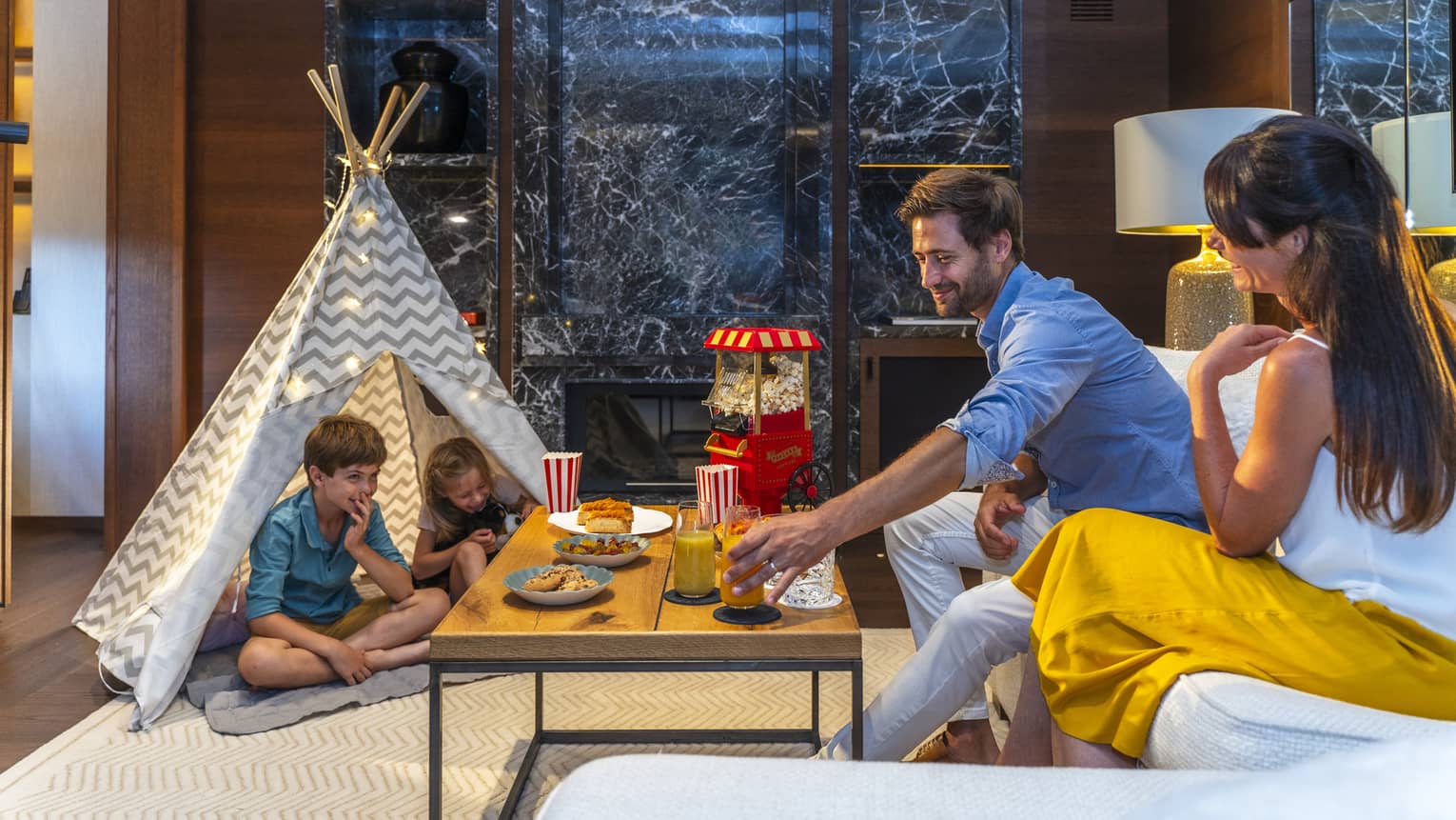 Family of four enjoying snacks in a room