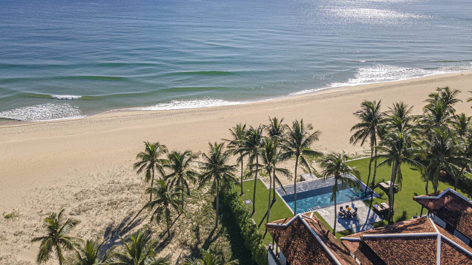 Three Bedroom Beachfront Pool Villa aerial view with ocean views and palm trees
