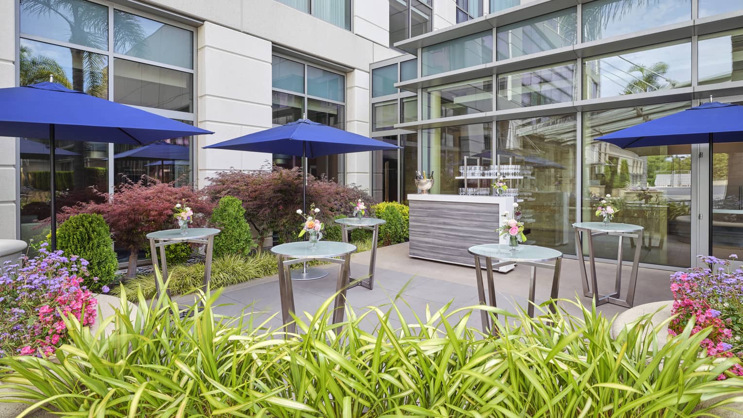 Outdoor dining patio with blue umbrellas with the tables.