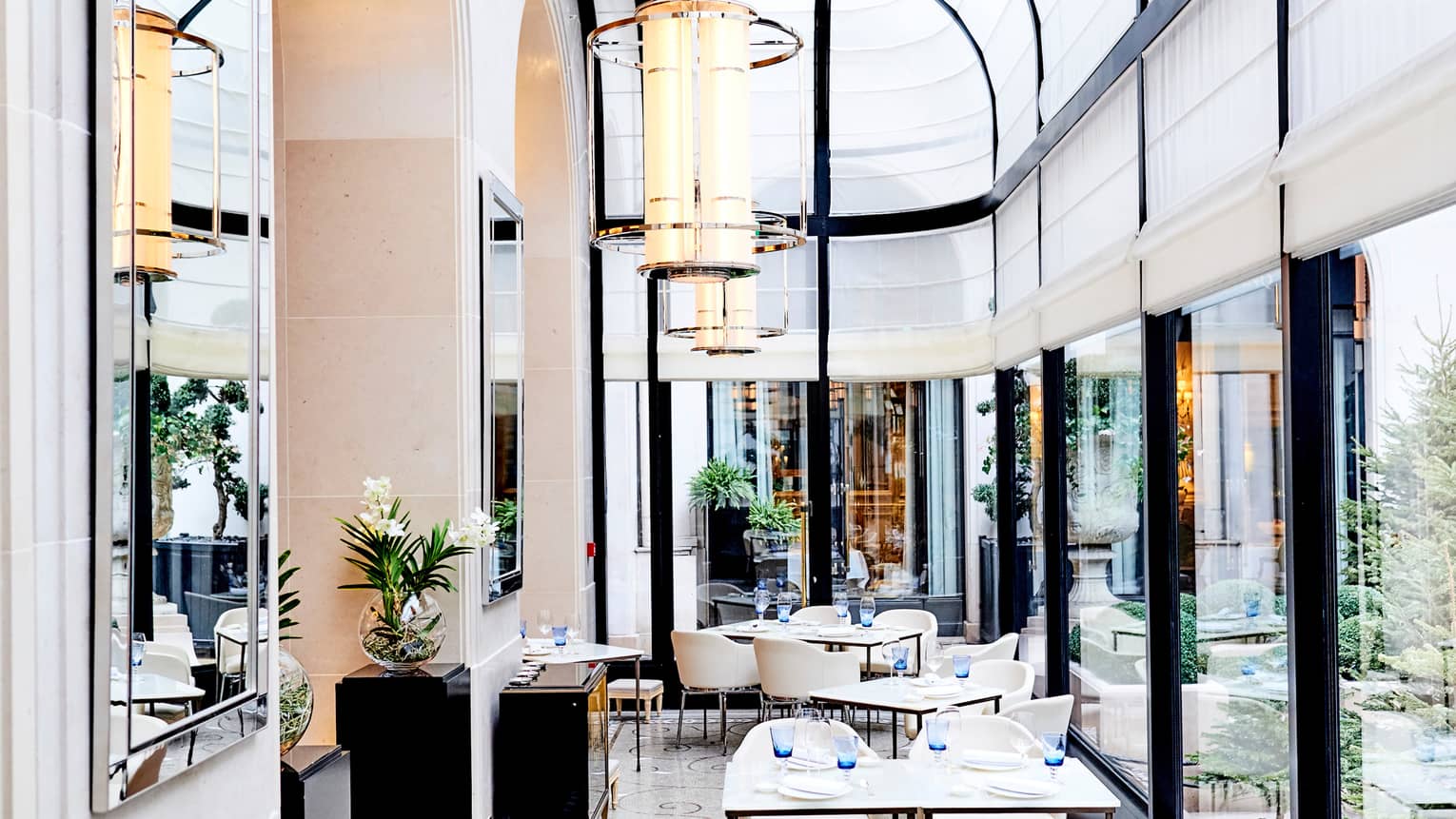 Le George dining room sunny conservatory with soaring ceilings, white canopies