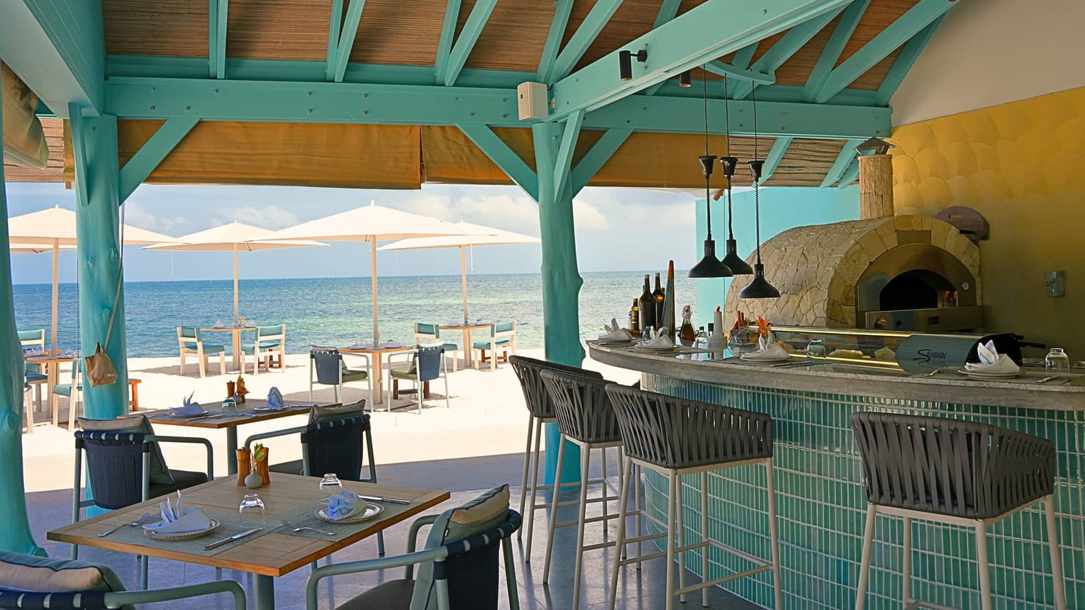 Covered outdoor restaurant with bar seating and an ocean view