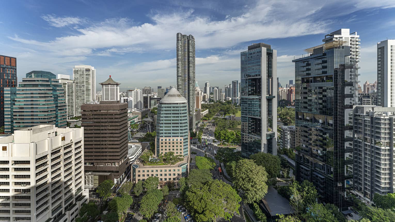 Bird's eye view of downtown Singapore, blue skies and trees