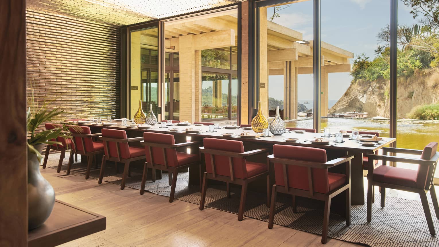 A private dining room with warm coloured chairs and large windows looking outside.