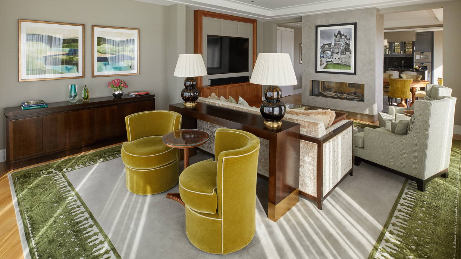 A seating area with chairs, sofa, shelves and art on the walls.