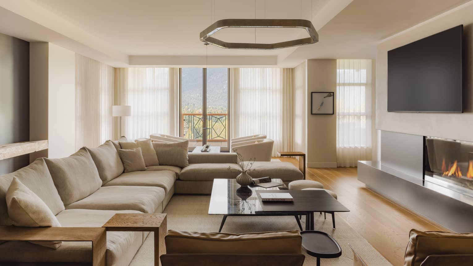 Modern living room of a mountain resort private residence, featuring large sectional sofa and fireplace