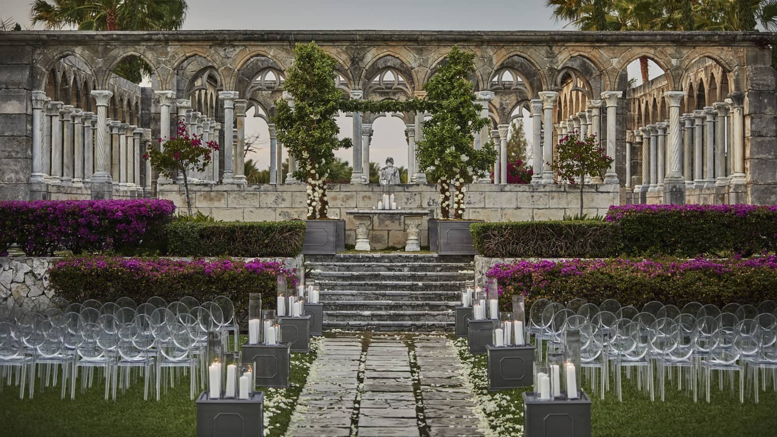 Rows of wedding chairs before wedding altar on stone steps to Beach Deck, pillars