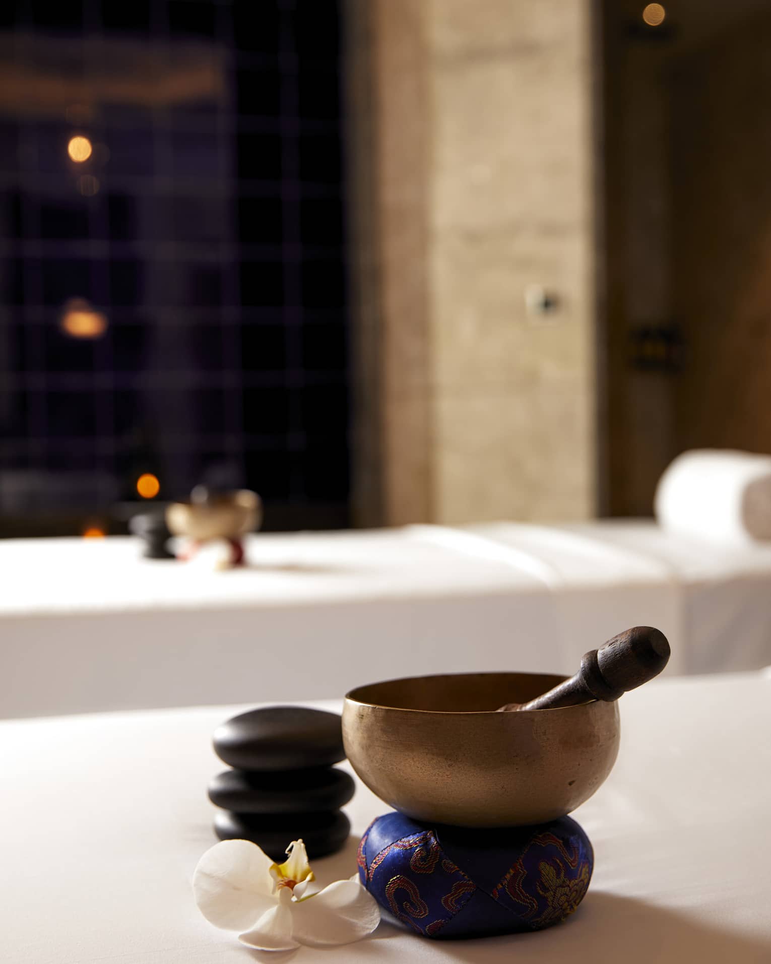 Copper bowl and wood spoon on couples spa treatment beds in spa