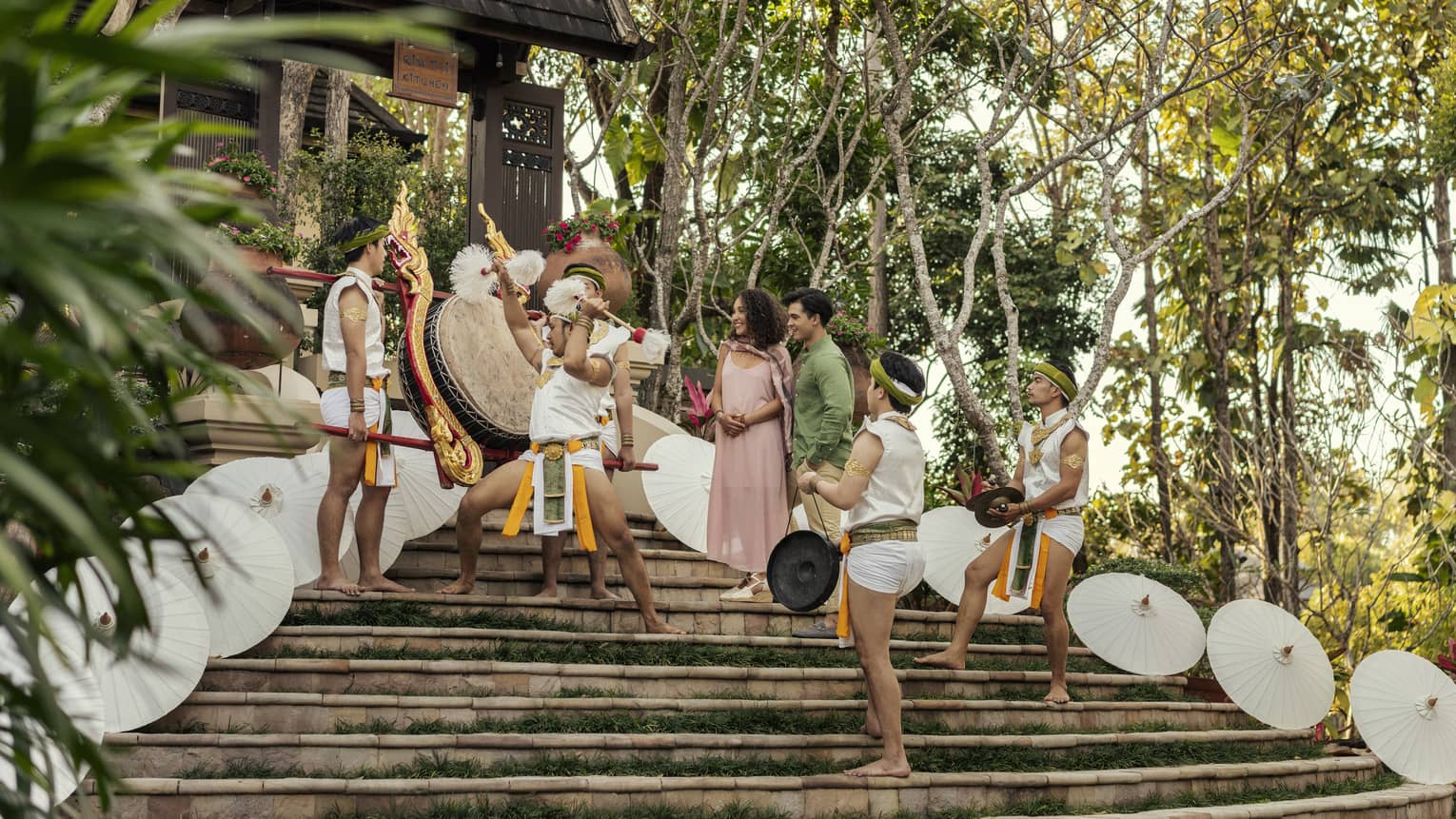 Traditional Lanna dancers perform for a couple on the steps of a temple