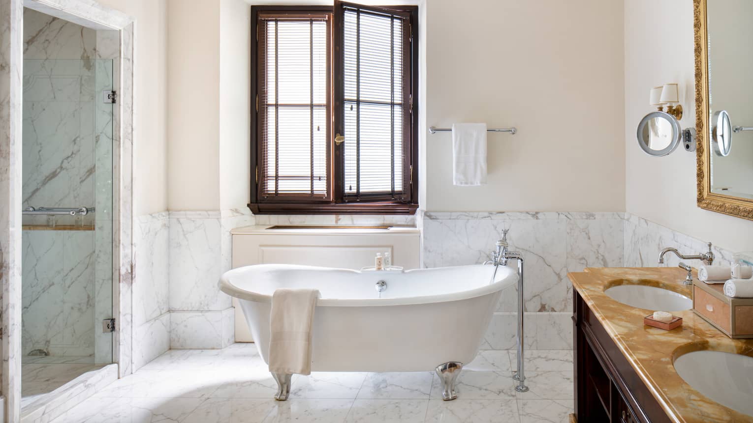 Bright Deluxe Room washroom with a shower, double sink and mirror and a clawfoot bathtub below an open window