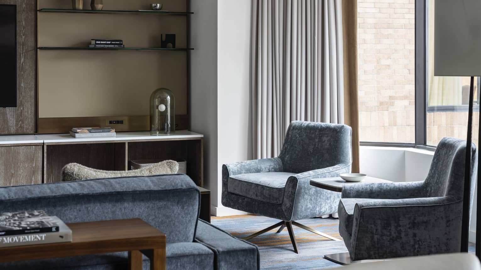 Residence at Four Seasons Hotel Houston, with shelving unit and light-blue chairs and couch near window