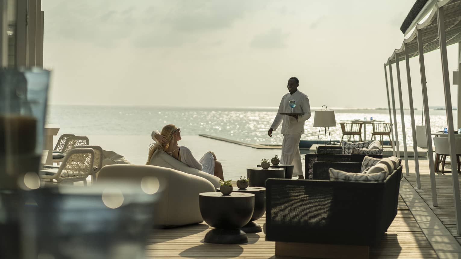 A guest receives a cocktail while relaxing outside at the Blu Beach Club