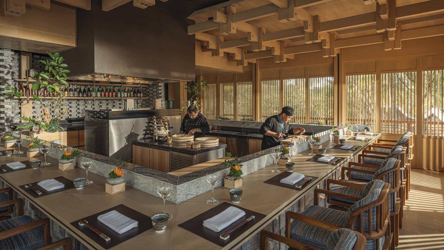 Two chefs prepare dishes behind omakase counter at bright and airy NAYUU restaurant
