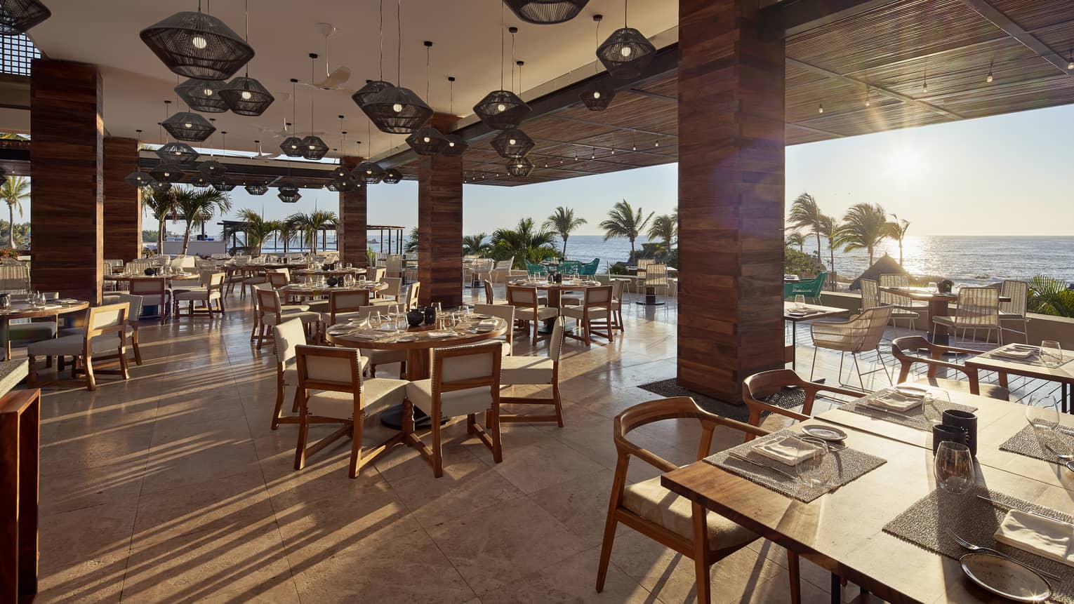 Sun streams into open air dining room with modern wood pillars 