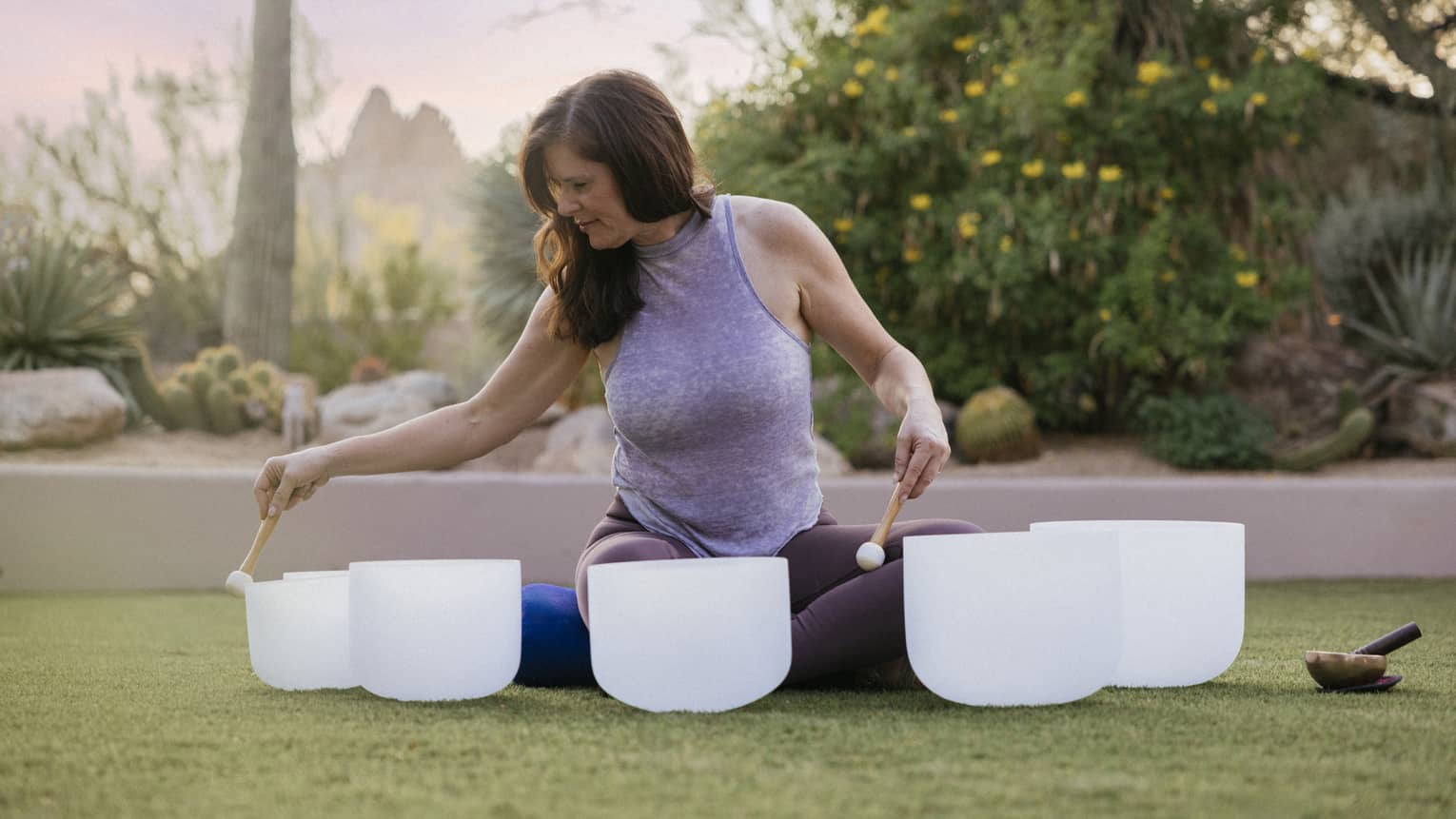 Person sitting outside doing a sound bowl meditation.