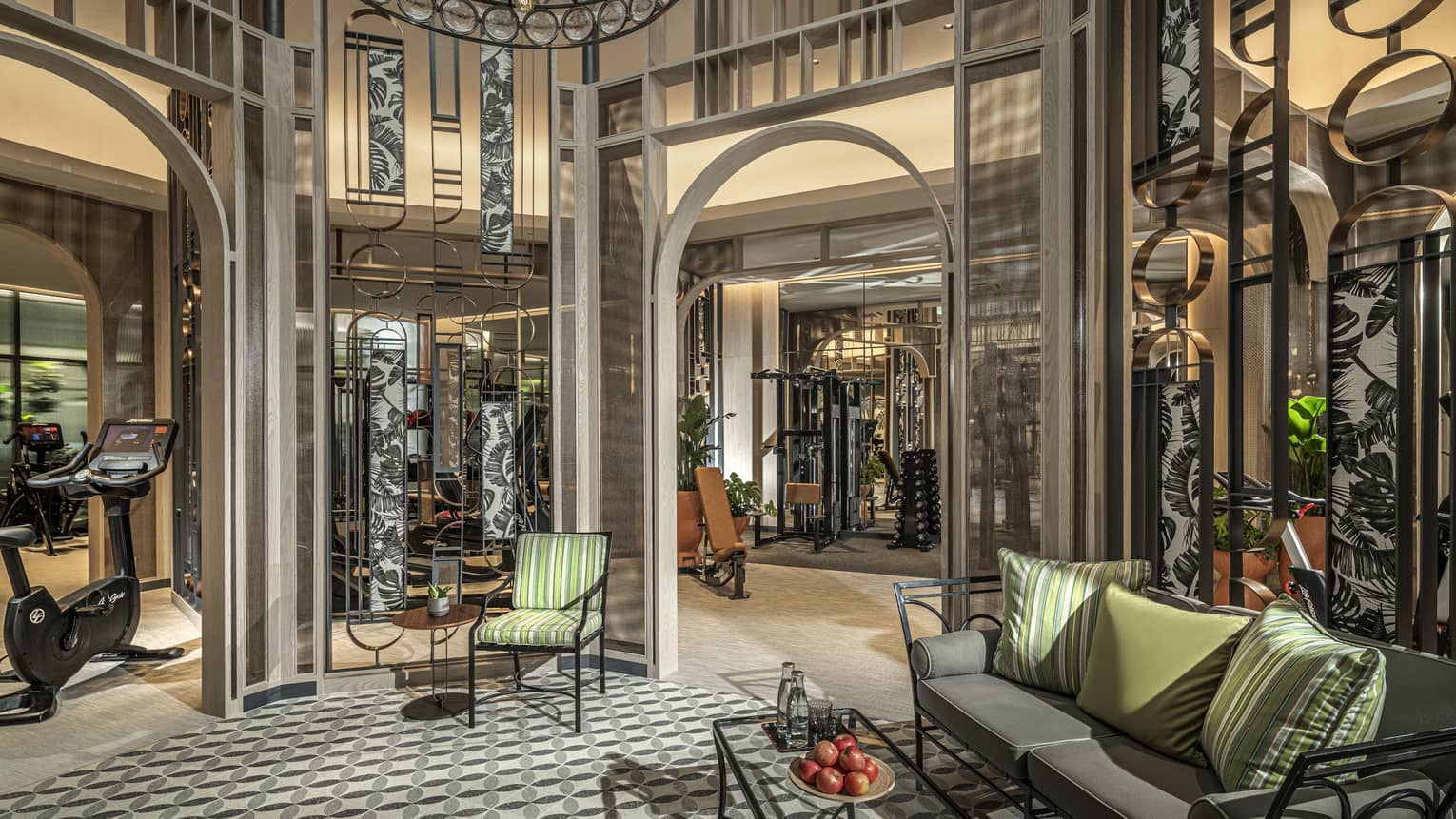 Fitness Centre lobby with high ceilings, round wrought-iron chandelier, sofa with green accent pillows