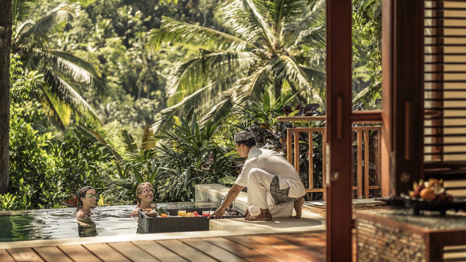 Guests relaxing and served drinks out of a floating basket in Bali