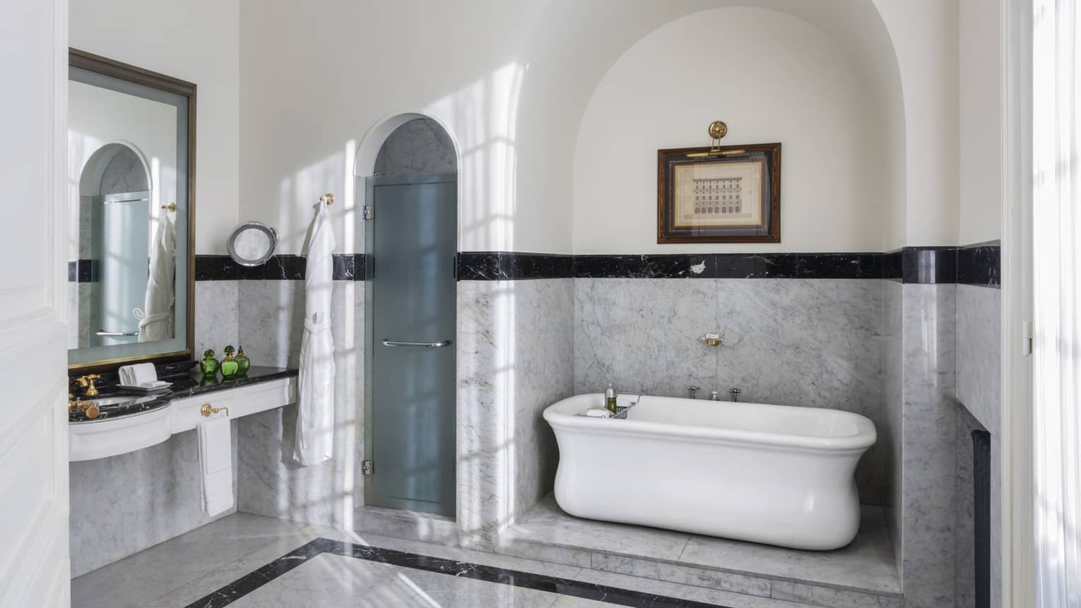 Large hotel suite bathroom, with free standing tub and marble floors and walls