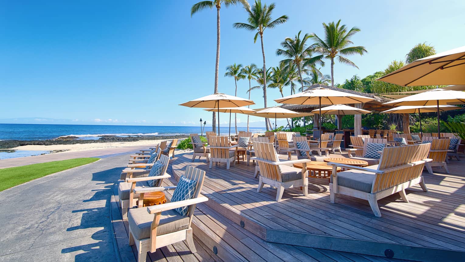 Beach Tree restaurant patio towering palm trees over wood deck, dining tables