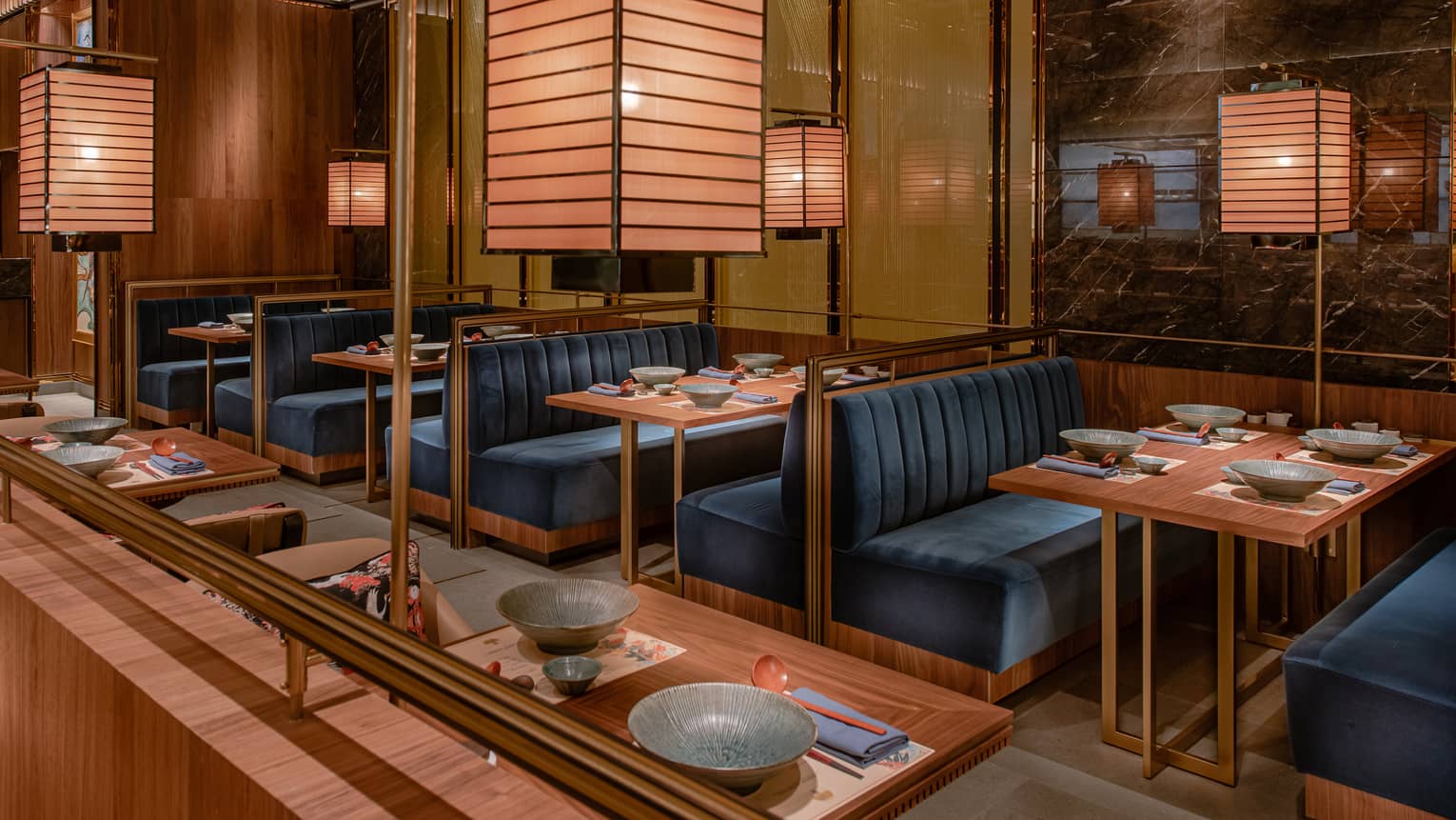 Plush dining booths beneath golden lighting at Four Seasons’ Ohte restaurant in Macao