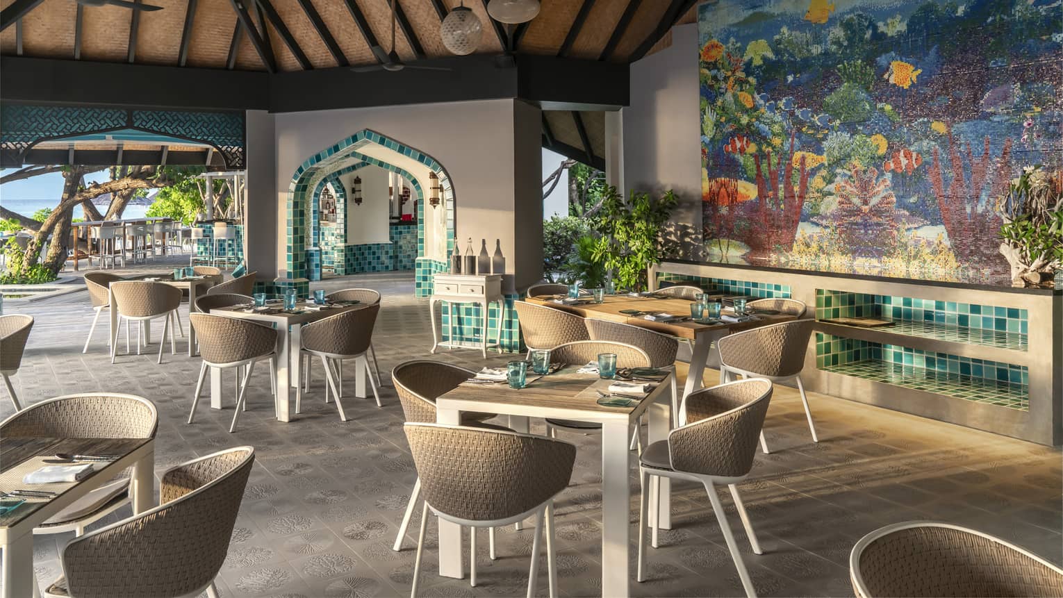 The Reef club is ready for guests with tables set for four with plates, napkins, silverware
