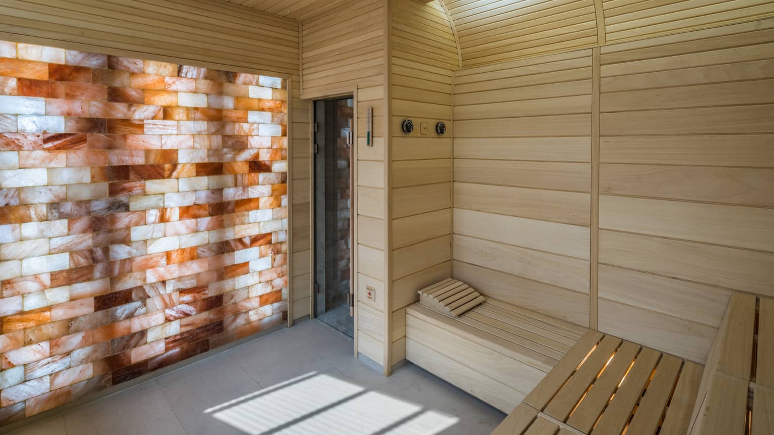 The Club wood sauna room with illuminated wall with wood, brick pattern