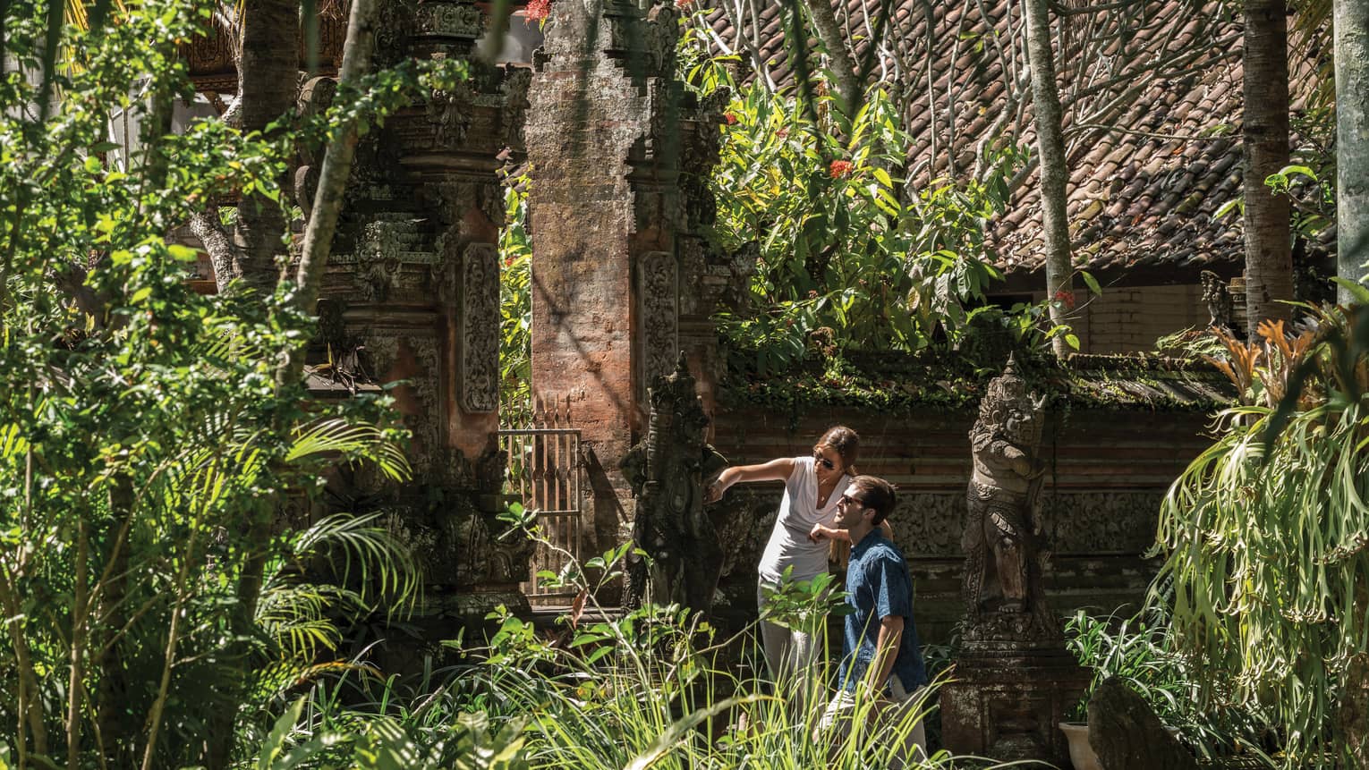 Gusts exploring decorative statues surrounding a temple in Bali