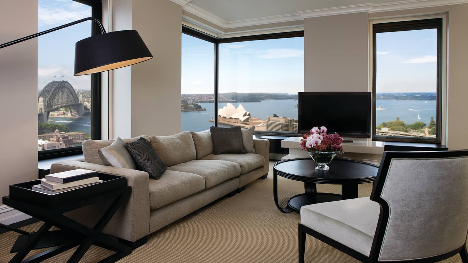 Presidential Suite reading lamp over long plush sofa, armchairs, table by sunny corner windows
