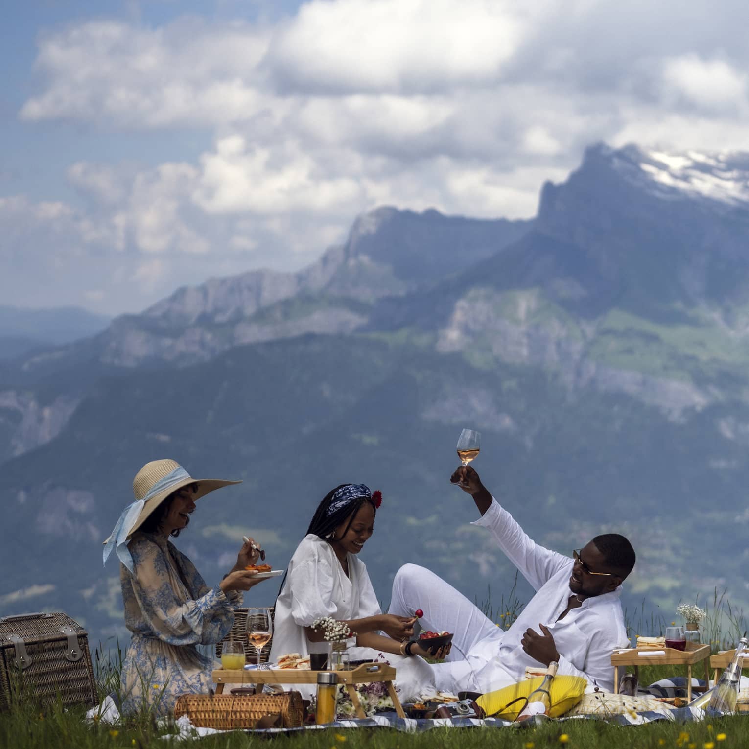 Three people enjoy gourmet picnic with ros� in French Alps