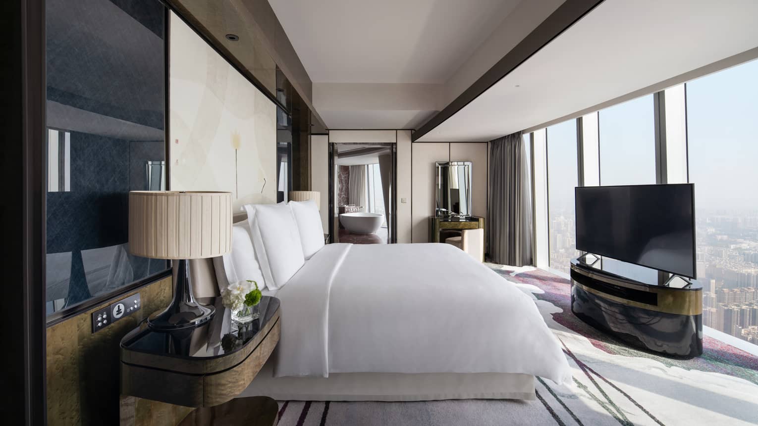 Deluxe King River View Suite with bed and white linens, floor-to-ceiling windows