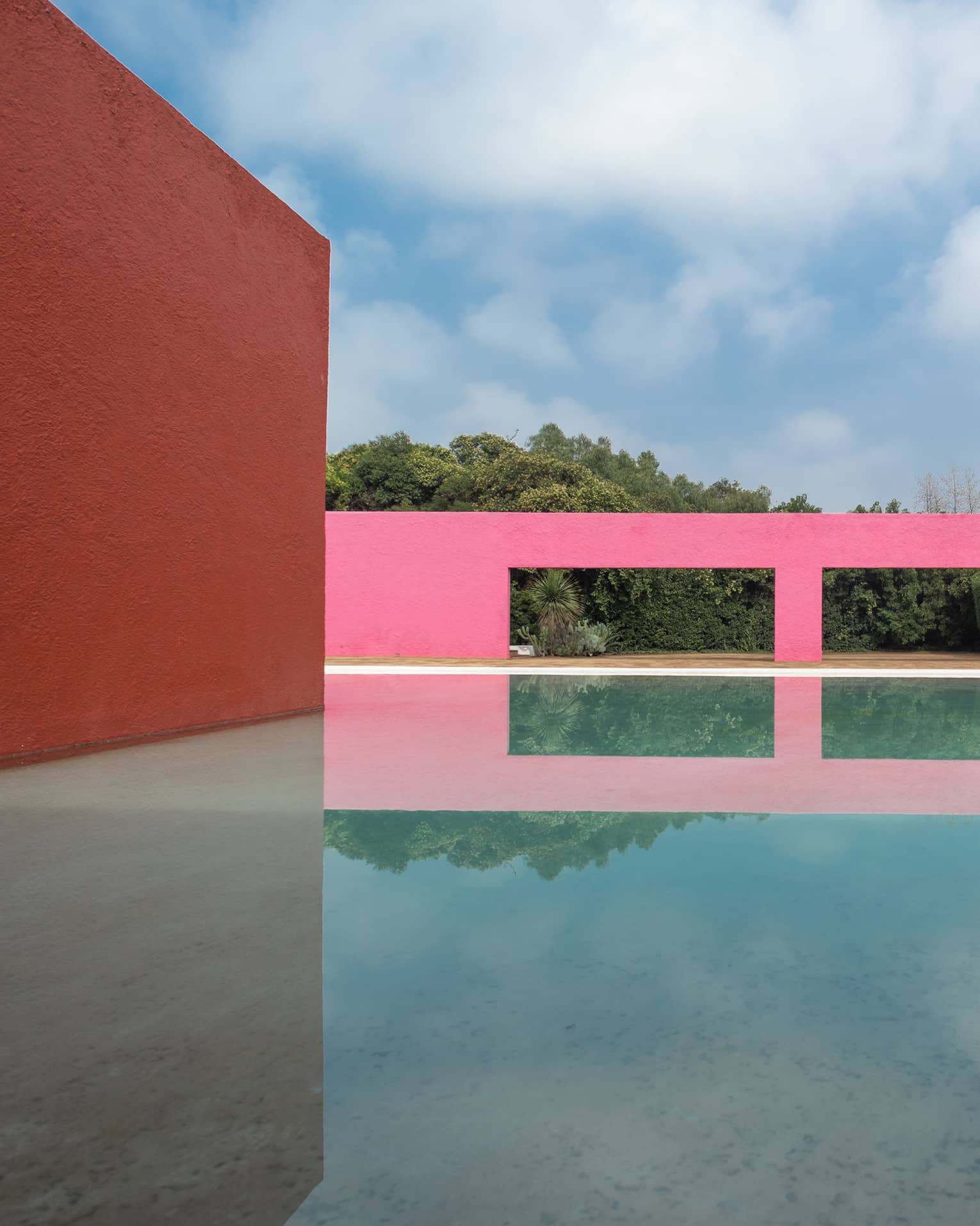 A pink building next to water outside.
