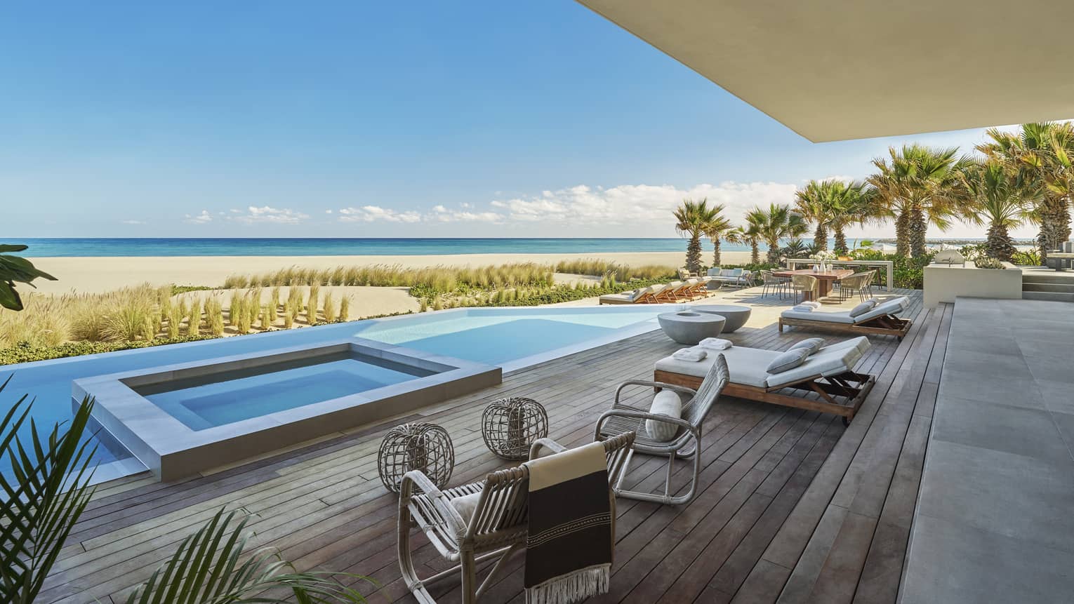 Private pool terrace with high-end lounge beds and chairs, and view of beach and sea, at Four Seasons Resort and Residences Los Cabos
