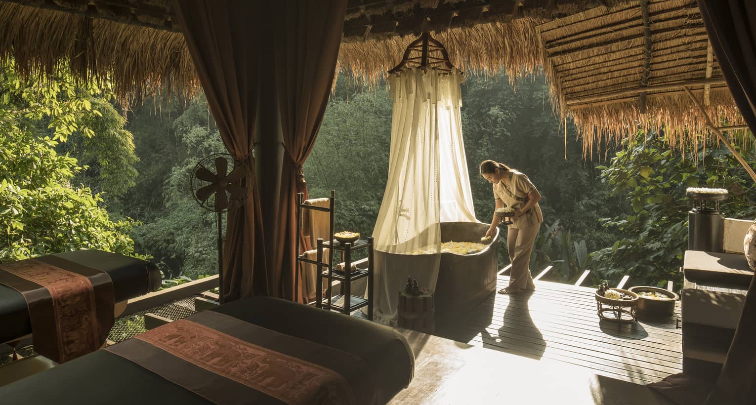 Woman prepares a bath on the jungle terrace