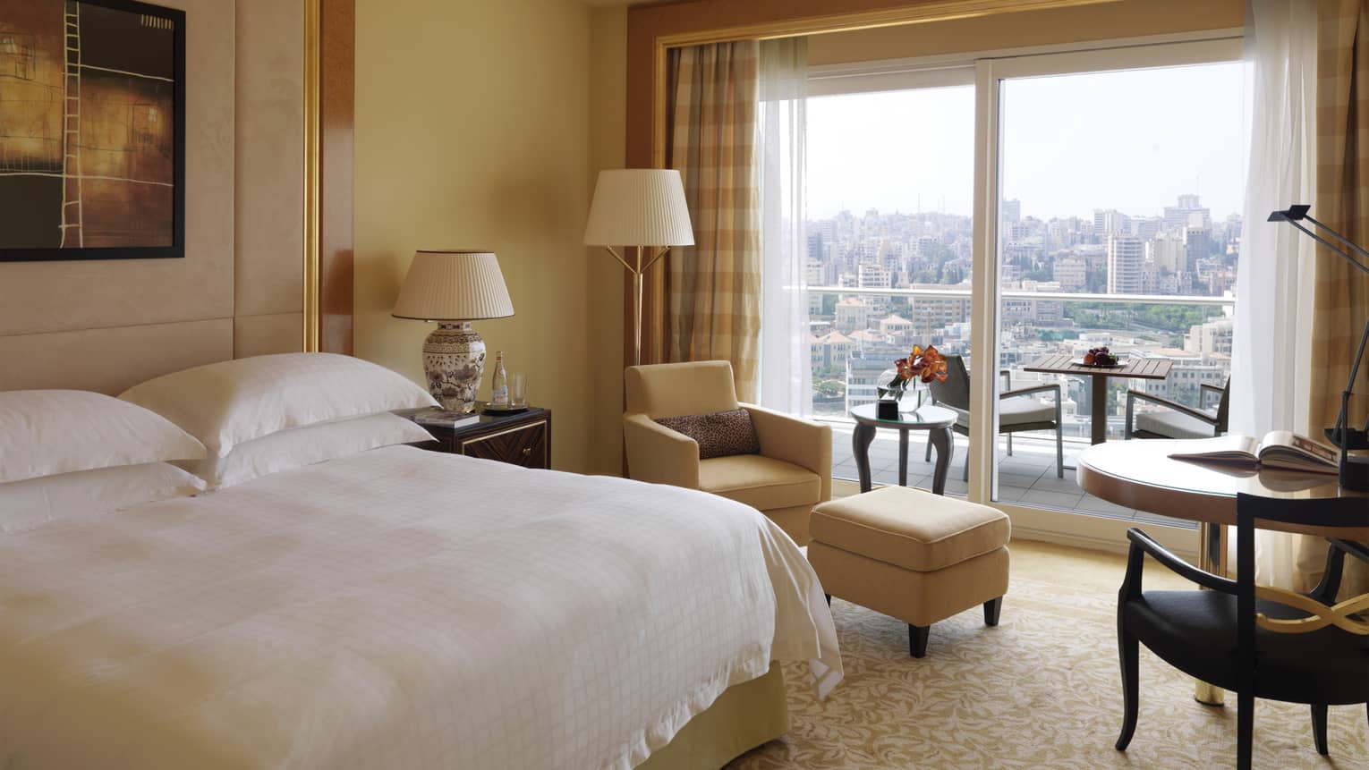 Superior City-View Room with king-size bed, yellow armchair and ottoman, small table, patio doors with city view