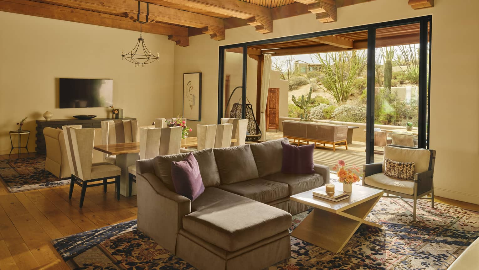 Luxury resort suite with sofa, coffee table, area rug, dining table, wooden ceilings and walk-out terrace