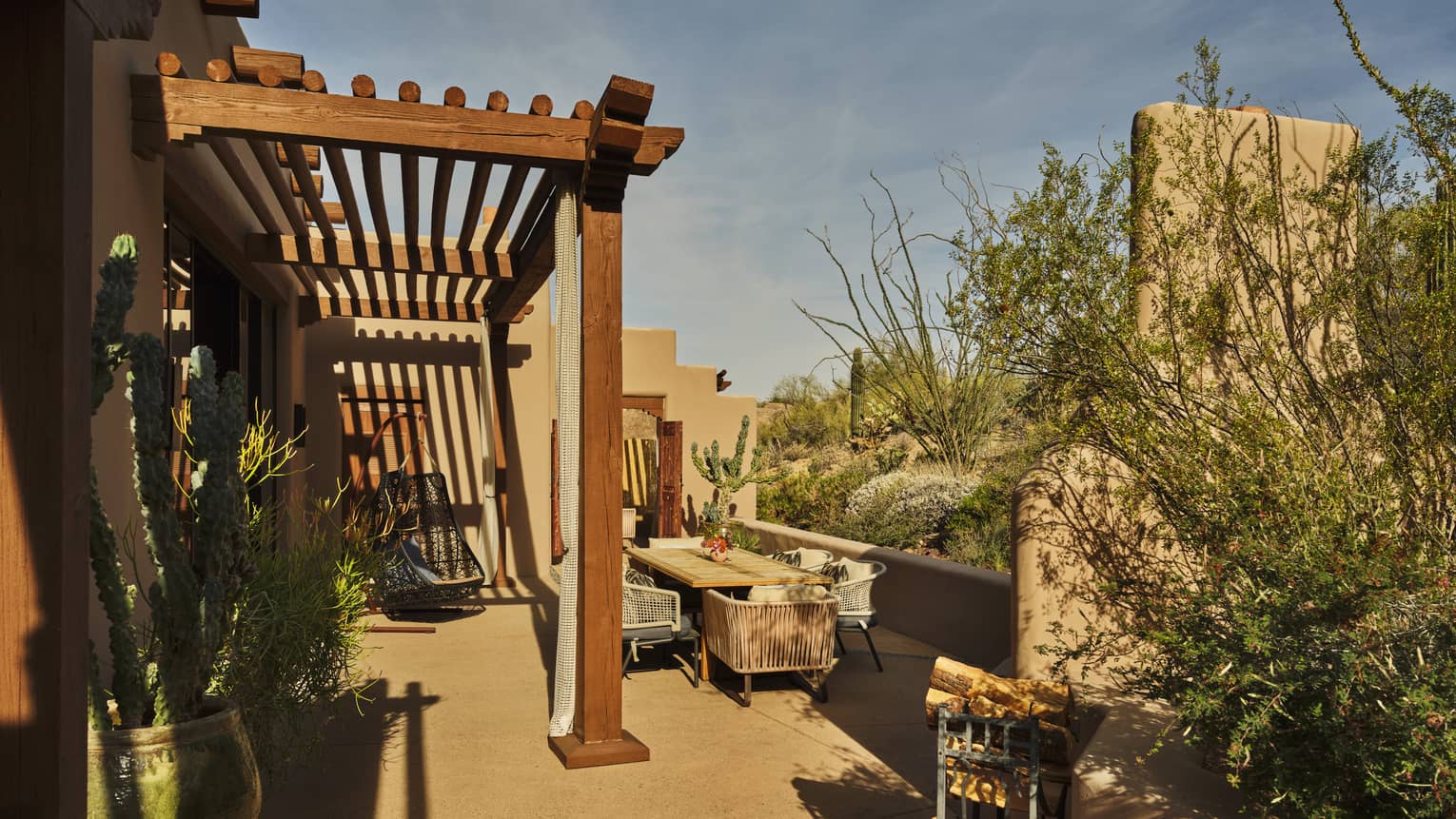 A private terrace of a luxury suite at a resort, featuring a pergola and desert views