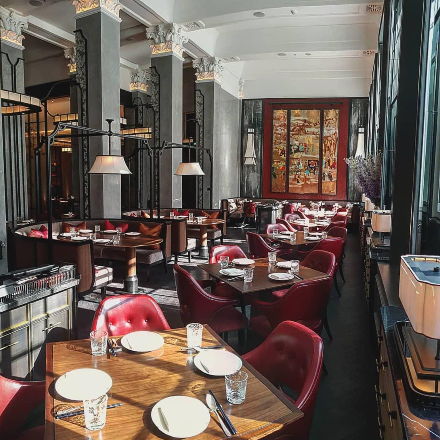 Elegant dining room, featuring wood tables and red leather chairs, creating a warm atmosphere