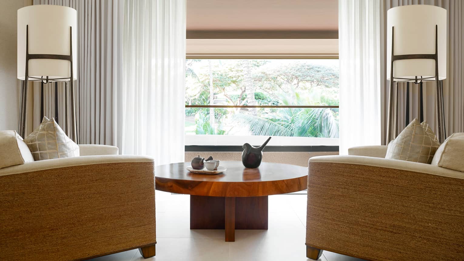 Large armchairs around wood table, sunny window in Couples Suite