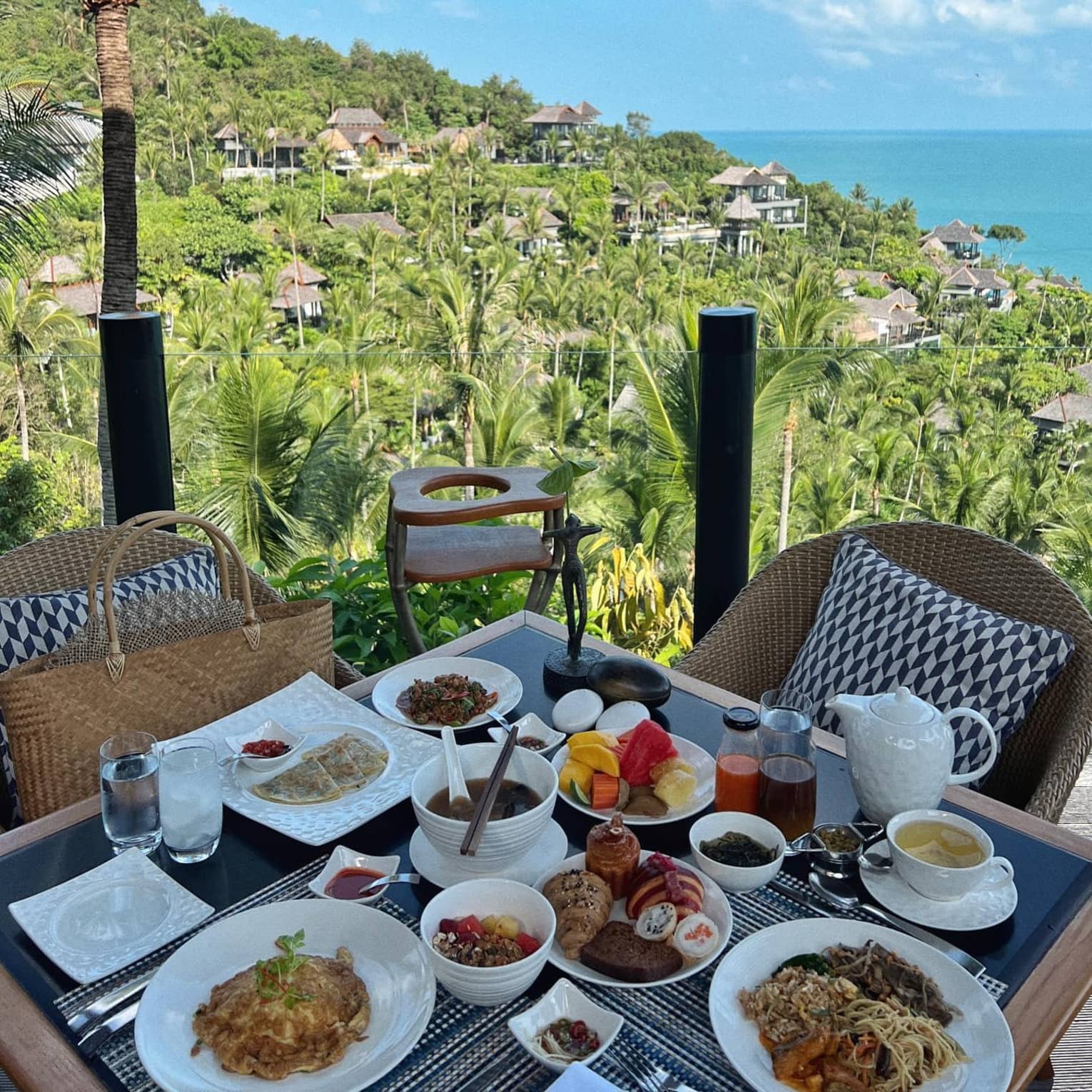 A spread of food and beverages served on an outdoor patio with a view