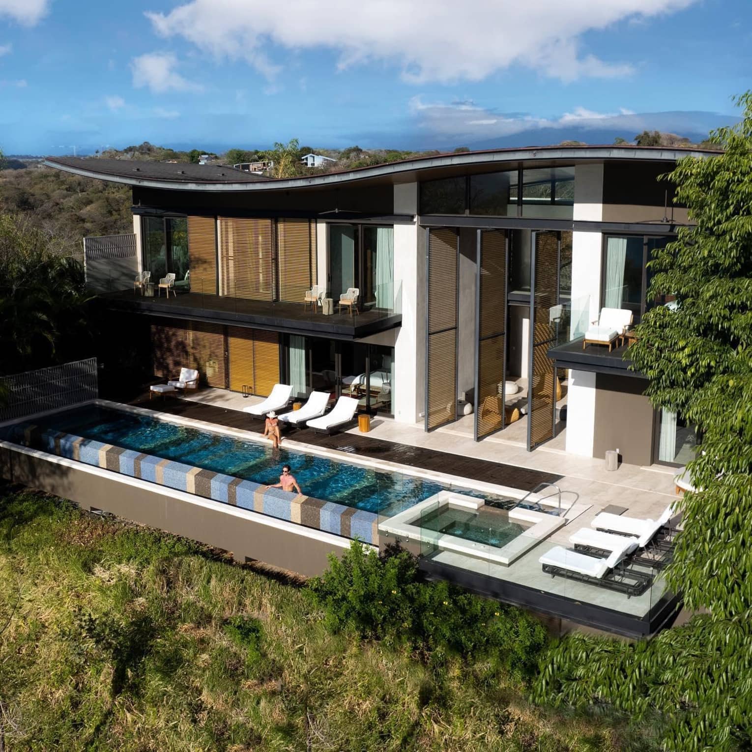 Two guests relax in the pool of a modern, luxurious private residence at Four Seasons Resort Peninsula Papagayo, Costa Rica