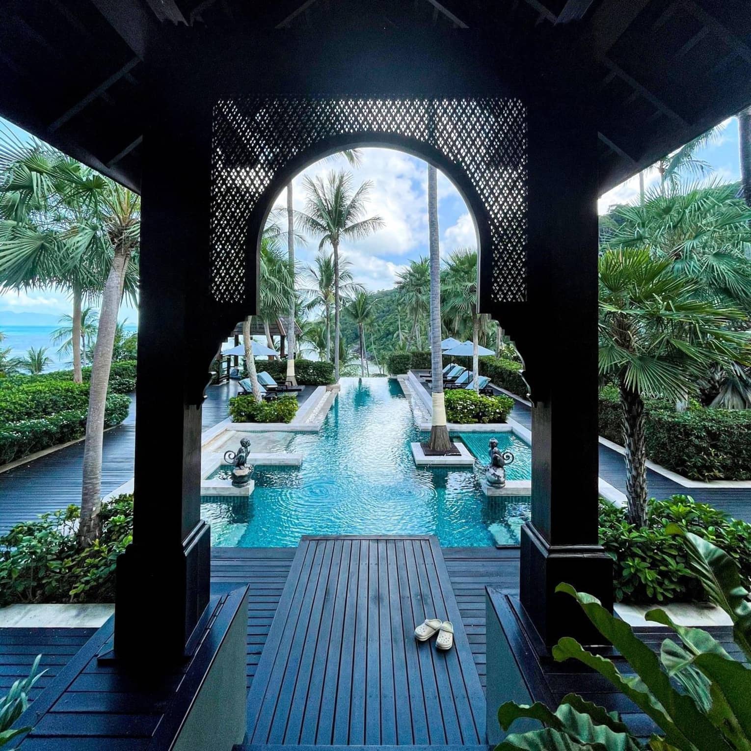 View of hotel pool from underneath breezeway