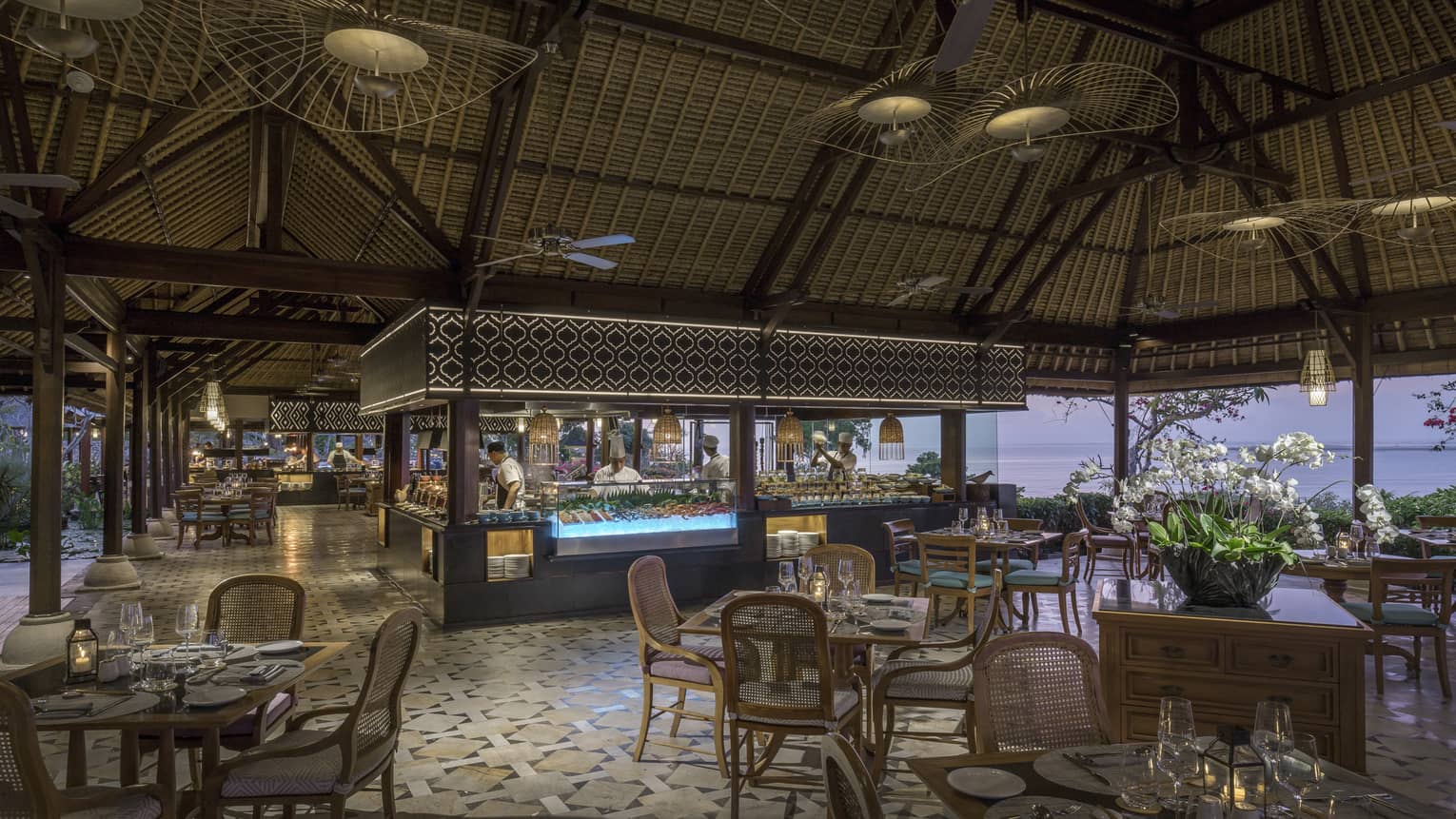 Taman Wantilan open air event space with dining tables, chefs at seafood bar
