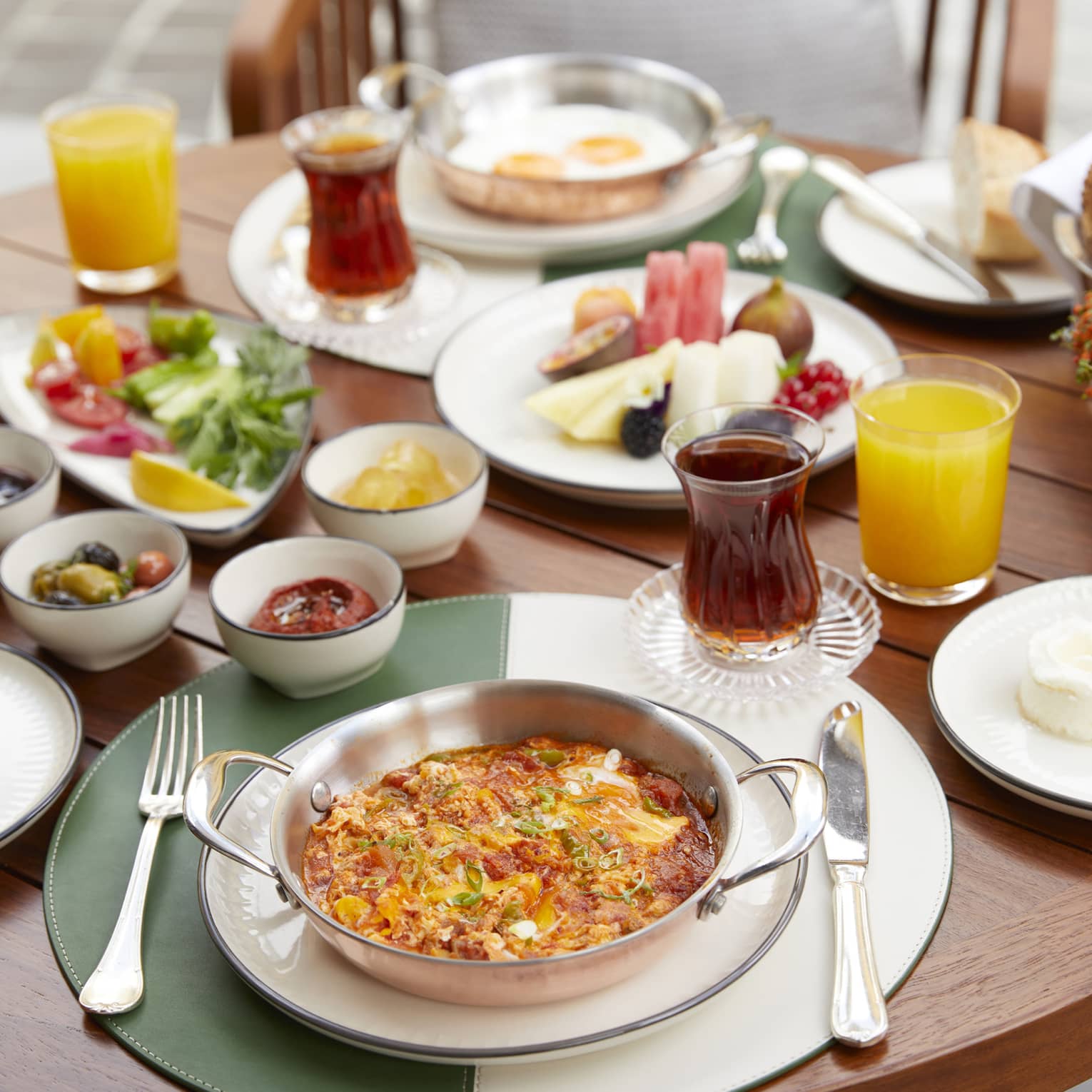 Breakfast meals, olives, cheeses and juices on patio dining table