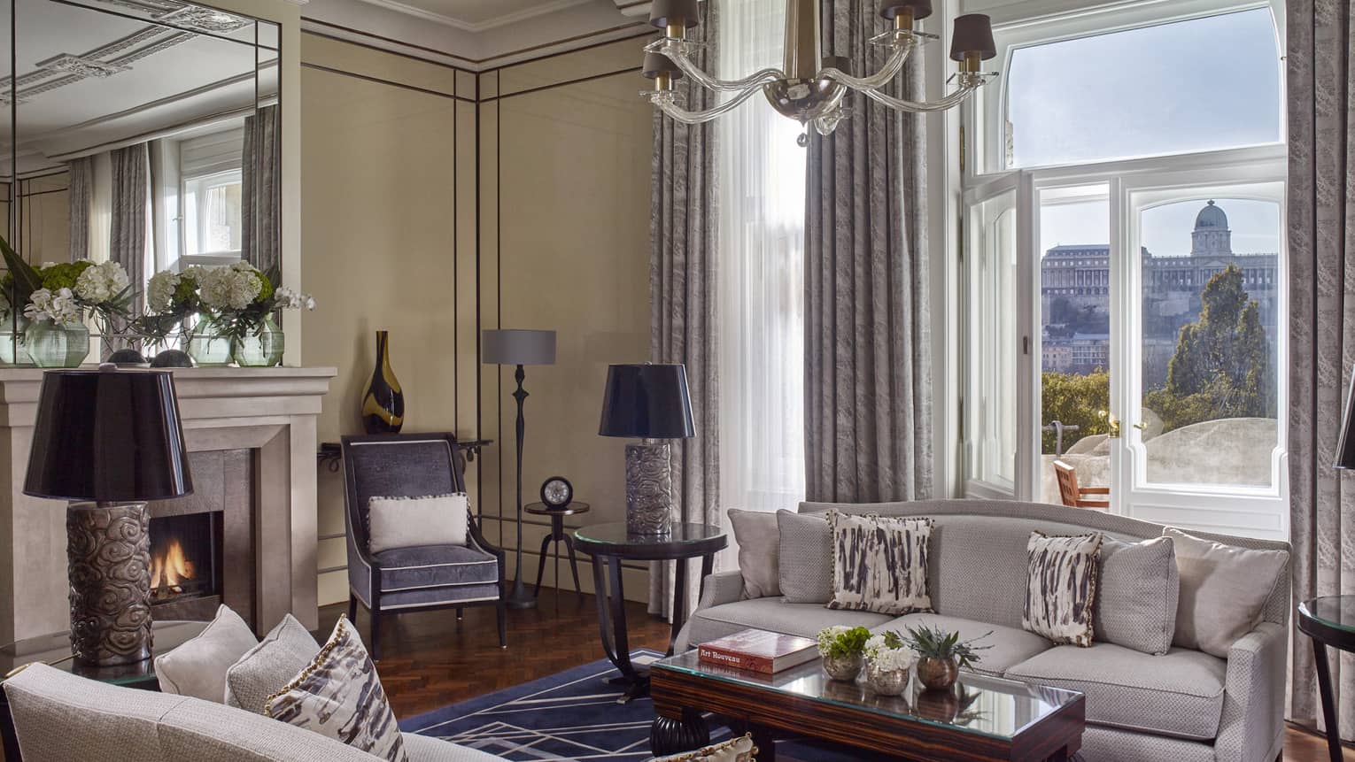 Royal Suite seating area with sofas, fireplace by large sunny window
