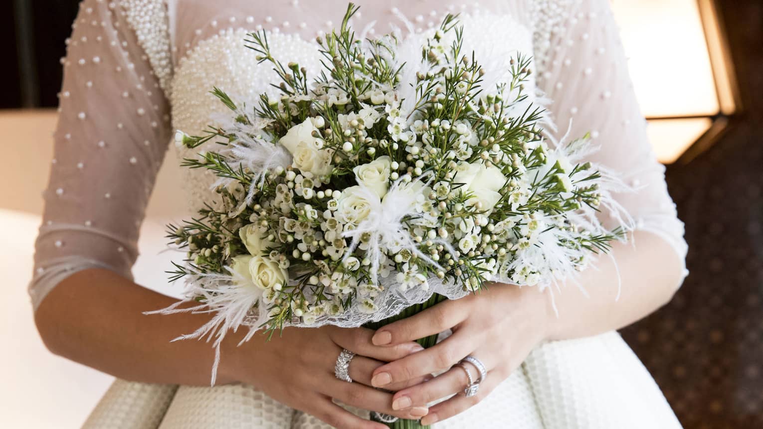 Bride holds large wedding floral bouquet with white flowers