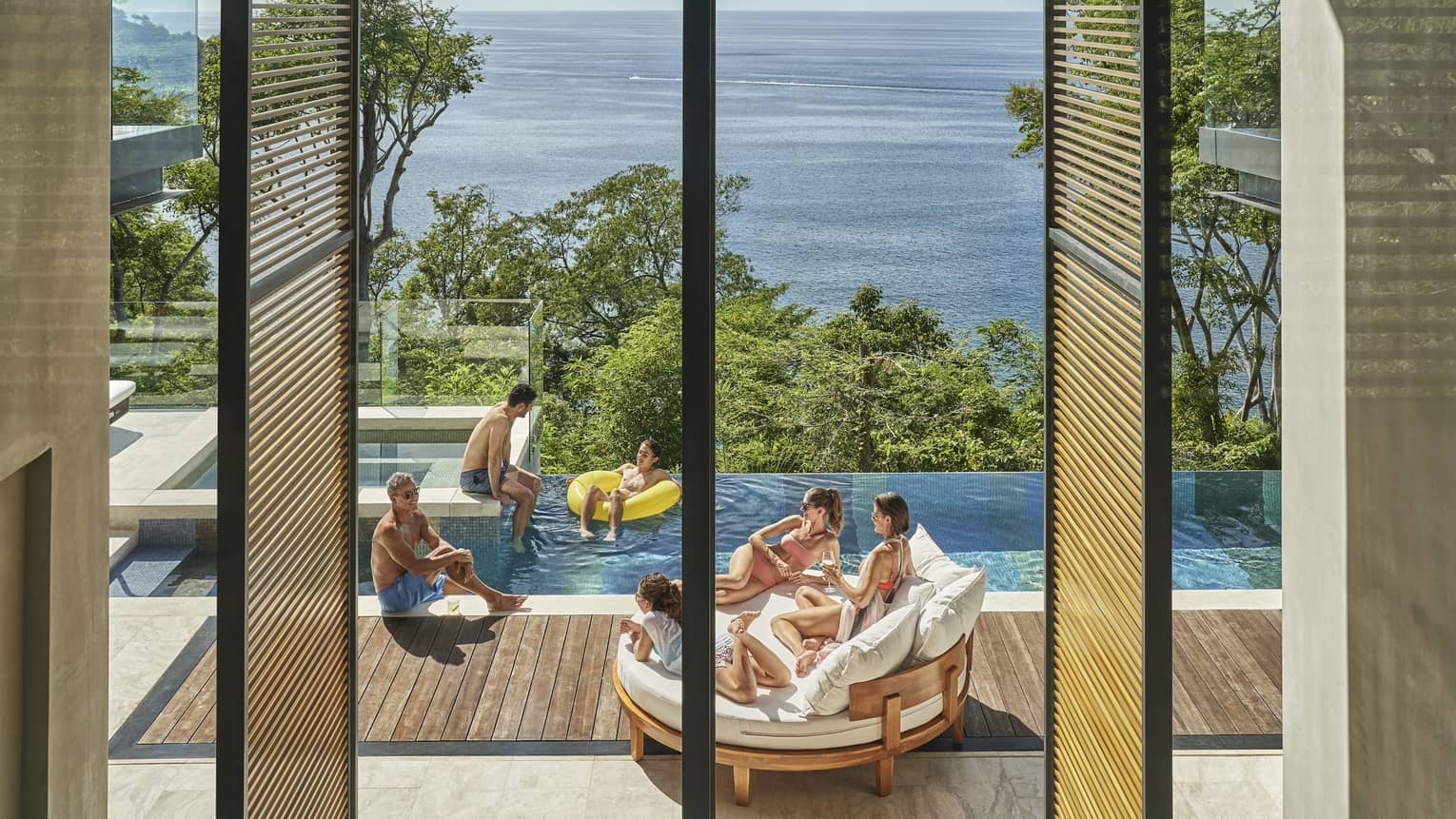 Family in private villa pool with ocean view