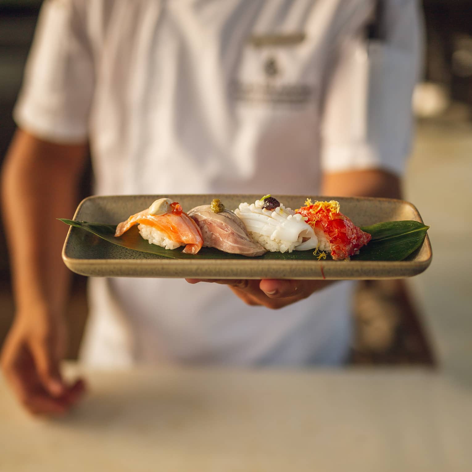 Chef holds a platter of nigiri selection