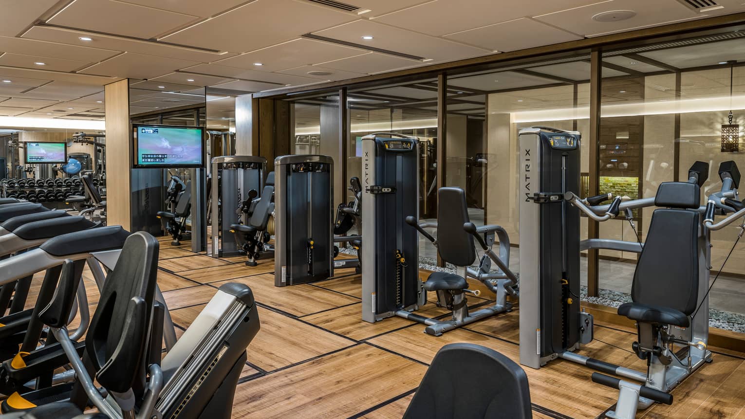 Cardio bikes, weight machines in front of glass wall in Fitness Centre