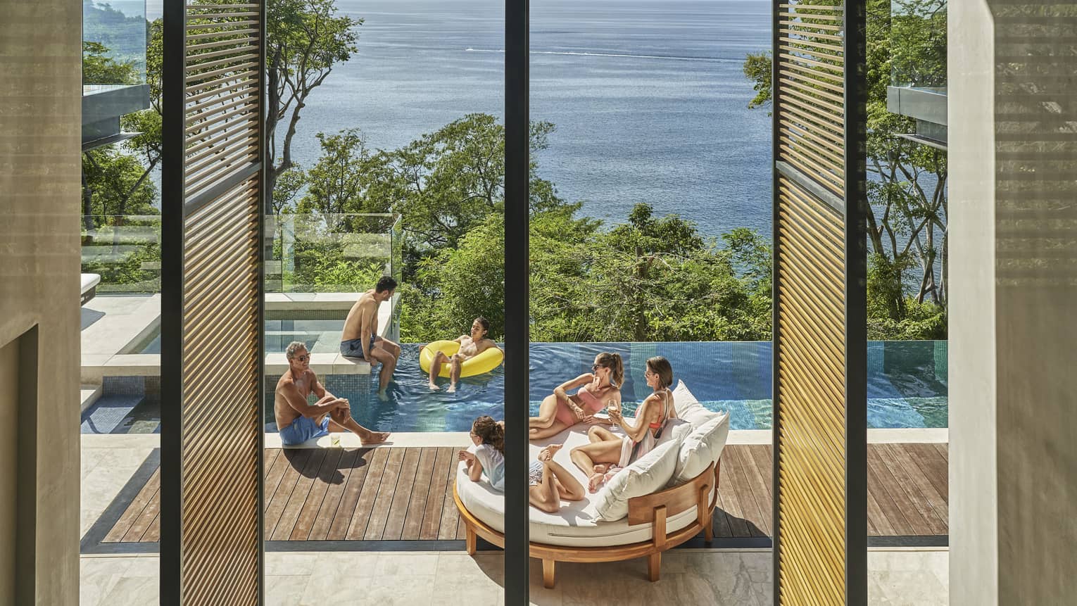 Family in private villa pool with ocean view