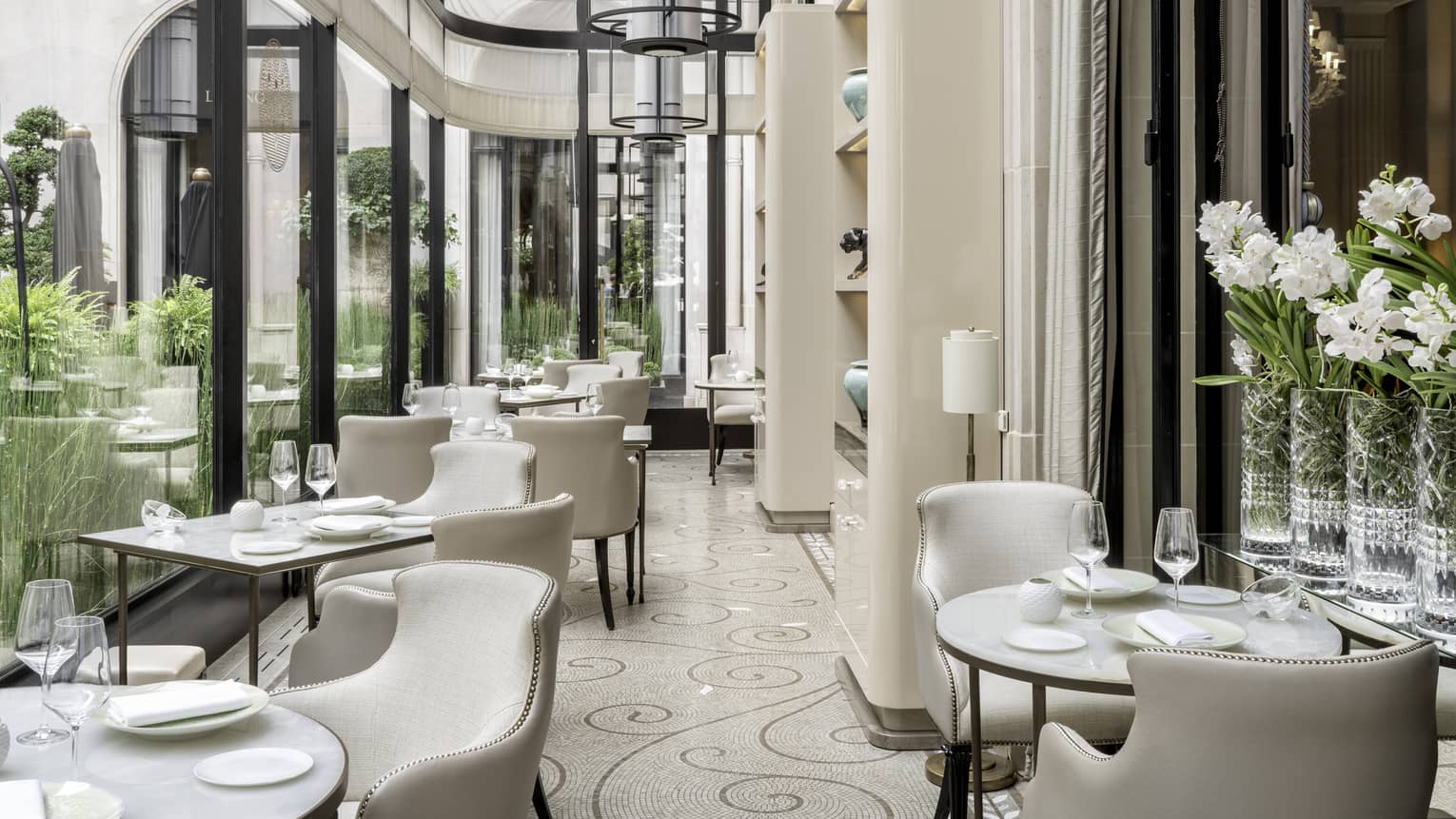 Set contemporary dining area with neutral decor, floor-to-ceiling windows and garden view